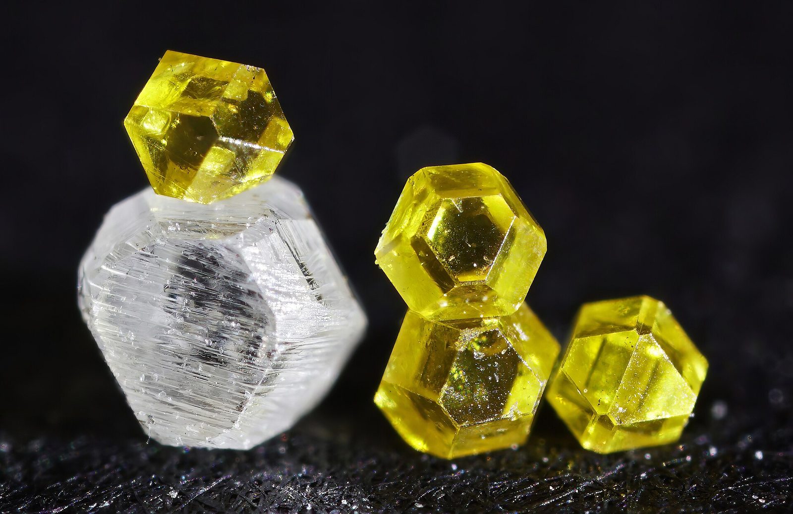 Syntetyczne diamenty o różnych odcieniach – żółta barwa to skutek większej zawartości azotu w sieci krystalicznej. Fot. Bilovitskiy / Wikimedia Commons, CC BY 4.0