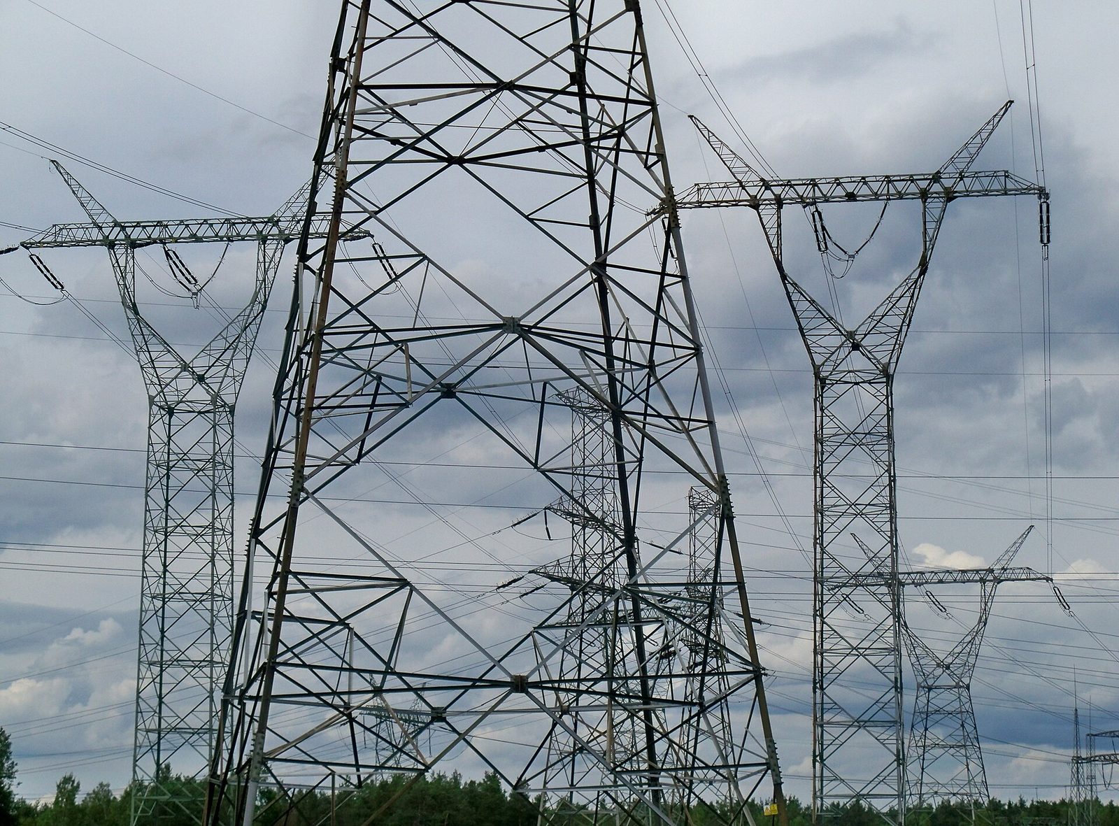 Linie wysokiego napięcia przy Elektrowni Kozienice, należącej do Enei. Spółka szacuje nową opłatę na ok. 240 mln zł rocznie. Fot. Panek / Wikimedia Commons, CC BY-SA 4.0